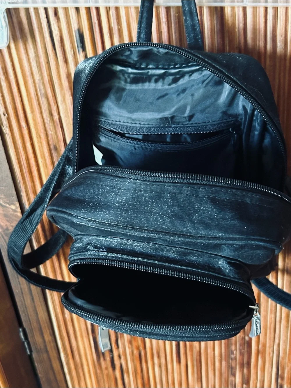Backpack mini style. Black little purse with lots of compartments and zippers.